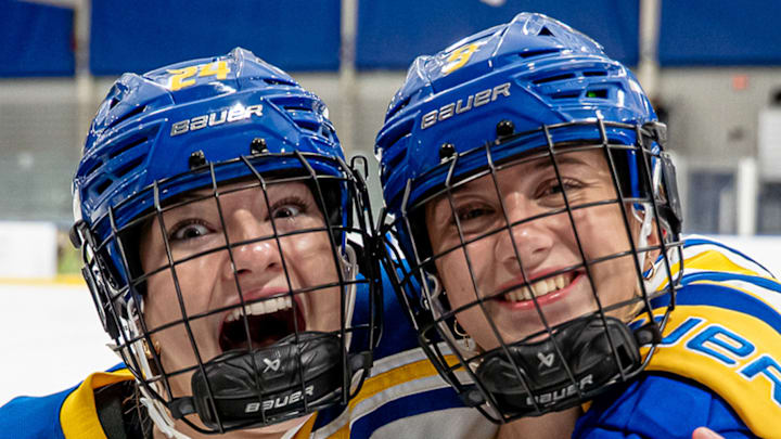 Freshman defenders Taylor Schooley (24) and Bailey Gray are all smiles after the Delaware Blue Hens earned the first women's hockey win in program history against Holy Cross on October 5, 2025.