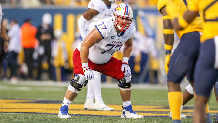 Sep 10, 2022; Morgantown, West Virginia, USA; Kansas Jayhawks offensive lineman Bryce Cabeldue (77) pauses before a snap during the second quarter against the West Virginia Mountaineers at Mountaineer Field at Milan Puskar Stadium.