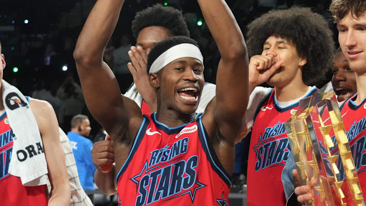 Feb 13, 2026; Inglewood, California, USA; Team Vince guard VJ Edgecombe (77) of the Philadelphia 76ers reacts with the MVP trophy after defeating Team Melo during an NBA All Star Rising Stars championship game at Intuit Dome. Mandatory Credit: Kirby Lee-Imagn Images