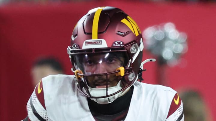 Jan 12, 2025; Tampa, Florida, USA; Washington Commanders quarterback Jayden Daniels (5) scrambles against the Tampa Bay Buccaneers during the second quarter of a NFC wild card playoff at Raymond James Stadium. Mandatory Credit: Kim Klement Neitzel-Imagn Images