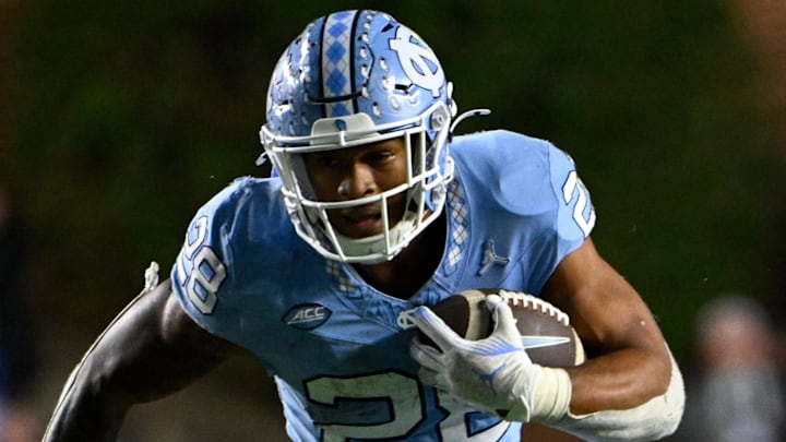 Nov 16, 2024; Chapel Hill, North Carolina, USA; North Carolina Tar Heels running back Omarion Hampton (28) runs as Wake Forest Demon Deacons defensive back Nick Andersen (45) defends in the third quarter at Kenan Memorial Stadium. Mandatory Credit: Bob Donnan-Imagn Images Nov 16, 2024; Chapel Hill, North Carolina, USA; North Carolina Tar Heels running back Omarion Hampton (28) runs as Wake Forest Demon Deacons defensive back Nick Andersen (45) defends in the third quarter at Kenan Memorial Stadium. Mandatory Credit: Bob Donnan-Imagn Images