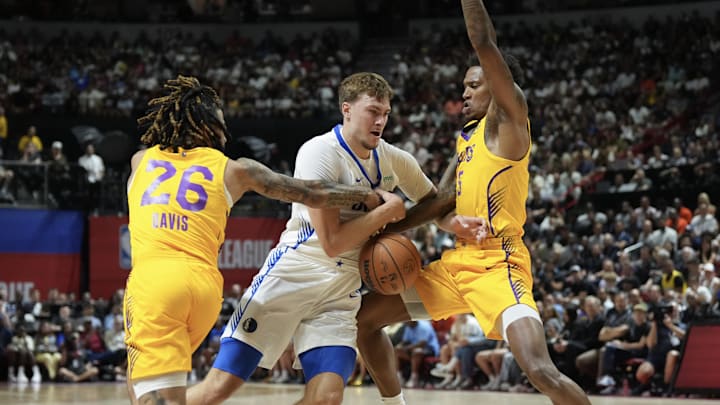 Jul 10, 2025; Las Vegas, NV, USA; Dallas Mavericks forward Cooper Flagg (32) dribbles against Los Angeles Lakers guard RJ Davis (26) and guard DaJaun Gordon (45) in the first quarter of their game at Thomas & Mack Center. Mandatory Credit: Candice Ward-Imagn Images