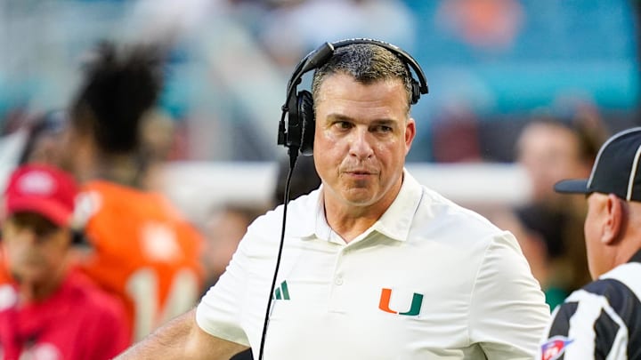 Nov 8, 2025; Miami Gardens, Florida, USA; Miami Hurricanes head coach Mario Cristobal talks to an official during a timeout in a game against the Syracuse Orange during the second quarter at Hard Rock Stadium. Mandatory Credit: Jeff Romance-Imagn Images