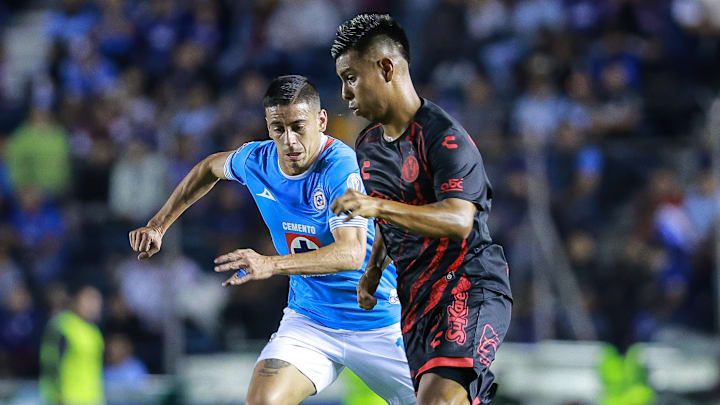El uruguayo Camilo Cándido de Cruz Azul busca robar el esférico a Efraín Álvarez de Tijuana 