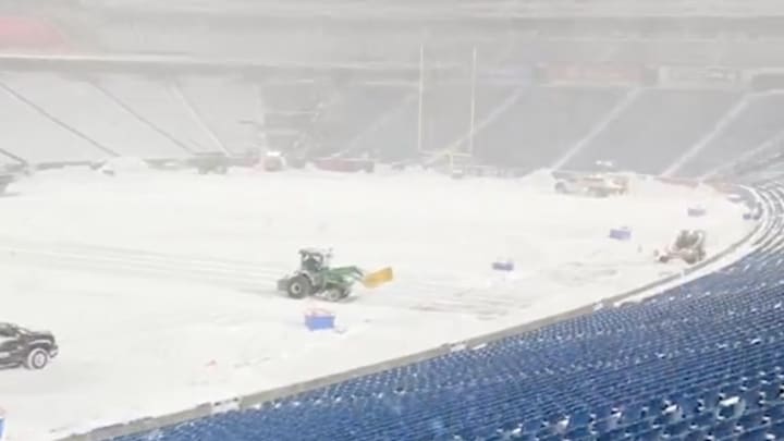 Snow removal crews work on the field at Highmark Stadium ahead of a Buffalo Bills game.