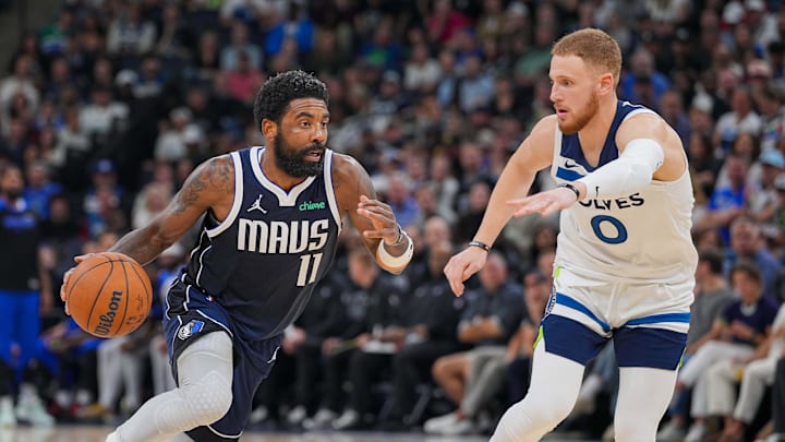 Oct 29, 2024; Minneapolis, Minnesota, USA; Dallas Mavericks guard Kyrie Irving (11) dribbles against the Minnesota Timberwolves guard Donte DiVincenzo (0) in the fourth quarter at Target Center. Mandatory Credit: Brad Rempel-Imagn Images