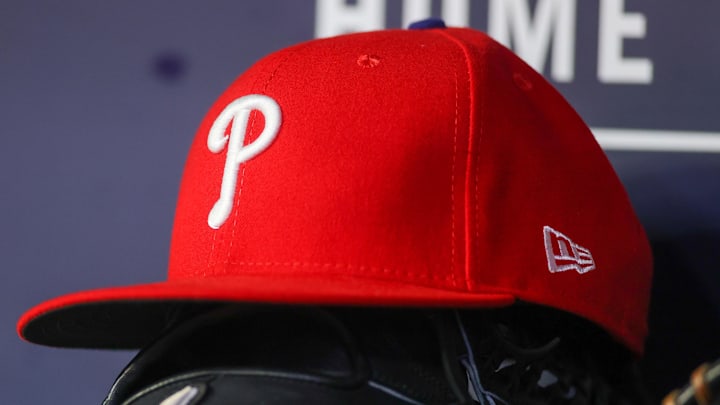 May 26, 2023; Atlanta, Georgia, USA; A detailed view of a Philadelphia Phillies hat and glove on the bench against the Atlanta Braves in the seventh inning at Truist Park. 