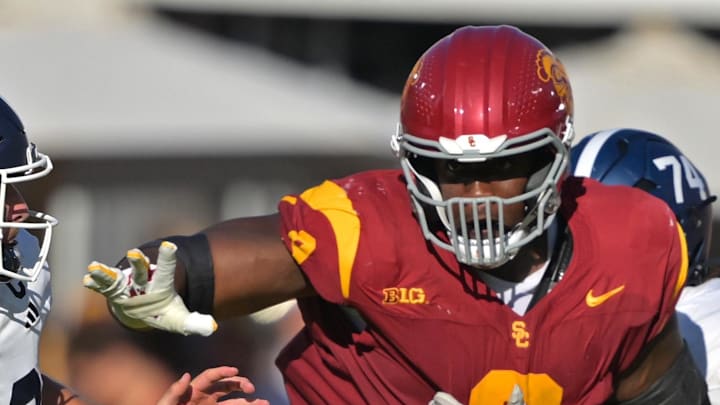 Sep 6, 2025; Los Angeles, California, USA;  Georgia Southern Eagles quarterback JC French IV (12) is pressured by Trojans defensive tackle Devan Thompkins (8) during the first half at United Airlines Field at the Los Angeles Memorial Coliseum. 