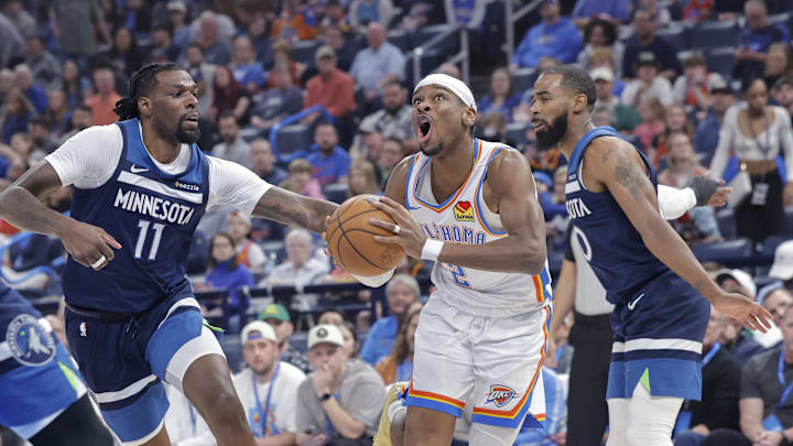 Feb 24, 2025; Oklahoma City, Oklahoma, USA; Oklahoma City Thunder guard Shai Gilgeous-Alexander (2) drives to the basket between Minnesota Timberwolves center Naz Reid (11) and guard Mike Conley (10) during the first quarter at Paycom Center. Mandatory Credit: Alonzo Adams-Imagn Images