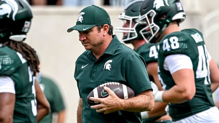 Michigan State's head coach Jonathan Smith holds a football as the team warms up before the game against Youngstown State on Saturday, Sept. 13, 2025, at Spartan Stadium in East Lansing.