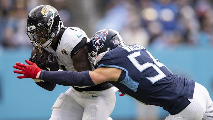 Jan 7, 2024; Nashville, Tennessee, USA;  Tennessee Titans linebacker Garrett Wallow (54) tackles Jacksonville Jaguars running back Travis Etienne Jr. (1) during the second half at Nissan Stadium. Mandatory Credit: Steve Roberts-Imagn Images