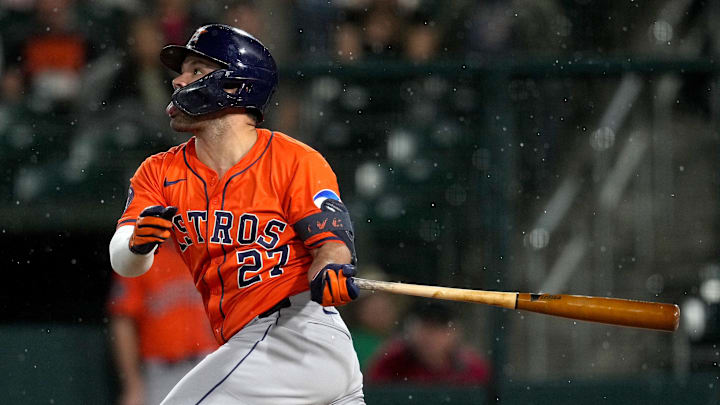 Houston Astros second baseman Jose Altuve swings a bat in an orange jersey and blue helmet Houston Astros second baseman Jose Altuve swings a bat in an orange jersey and blue helmet