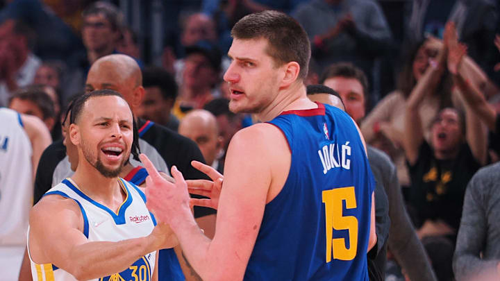 Golden State Warriors guard Stephen Curry (30) and Denver Nuggets center Nikola Jokic (15) in a confrontation as a time out is called during the first quarter of game two of the first round for the 2022 NBA playoffs at Chase Center. Mandatory Credit: Kelley L Cox-Imagn Images