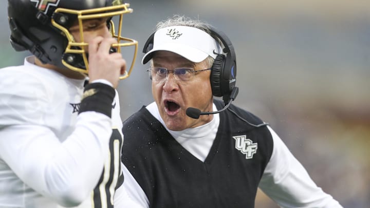 Nov 23, 2024; Morgantown, West Virginia, USA; UCF Knights head coach Gus Malzahn yells at quarterback Dylan Rizk (10) during the first quarter against the West Virginia Mountaineers at Mountaineer Field at Milan Puskar Stadium. Mandatory Credit: Ben Queen-Imagn Images Nov 23, 2024; Morgantown, West Virginia, USA; UCF Knights head coach Gus Malzahn yells at quarterback Dylan Rizk (10) during the first quarter against the West Virginia Mountaineers at Mountaineer Field at Milan Puskar Stadium. Mandatory Credit: Ben Queen-Imagn Images