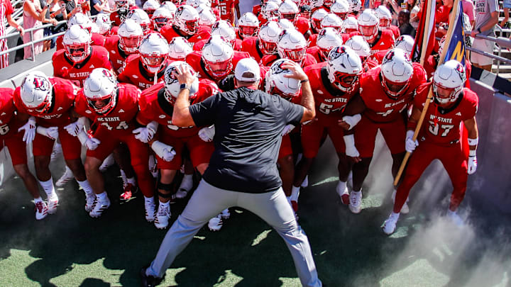 Oct 4, 2025; Raleigh, North Carolina, USA;  NC State Wolfpack head coach Dave Doeren with his team prepare to run out prior to the first half of the game against Campbell Fighting Camels at Carter-Finley Stadium. Mandatory Credit: Jaylynn Nash-Imagn Images