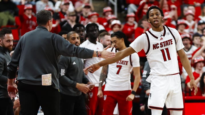 Feb 7, 2026; Raleigh, North Carolina, USA;  NC State Wolfpack guard Quadir Copeland (11) and head coach Will Wade react during the second half of the game against the Virginia Tech Hokies at Lenovo Center. Mandatory Credit: Jaylynn Nash-Imagn Images