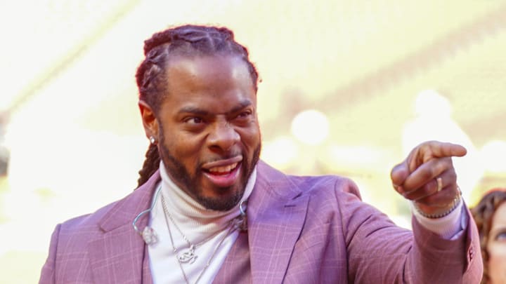 Former Seattle Seahawks cornerback Richard Sherman signals to fans