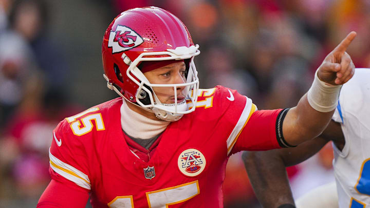 Dec 14, 2025; Kansas City, Missouri, USA; Kansas City Chiefs quarterback Patrick Mahomes (15) scrambles against Los Angeles Chargers linebacker Odafe Oweh (98) during the second half at GEHA Field at Arrowhead Stadium. Mandatory Credit: Jay Biggerstaff-Imagn Images