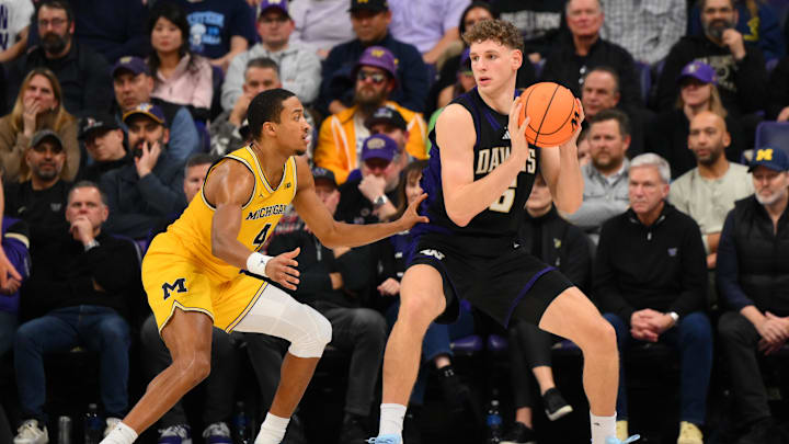 Jan 14, 2026; Seattle, Washington, USA; Washington Huskies forward Hannes Steinbach (6) protects the ball while guarded by Michigan Wolverines guard Nimari Burnett (4) during the second half at Alaska Airlines Arena at Hec Edmundson Pavilion. Mandatory Credit: Steven Bisig-Imagn Images