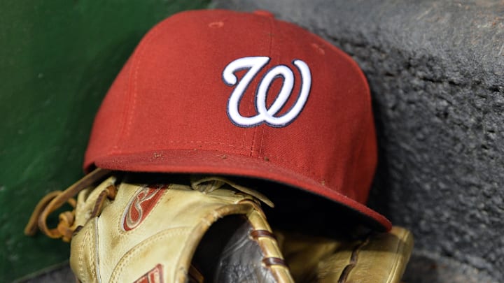 Red Washington Nationals hat on top of a light brown mitt