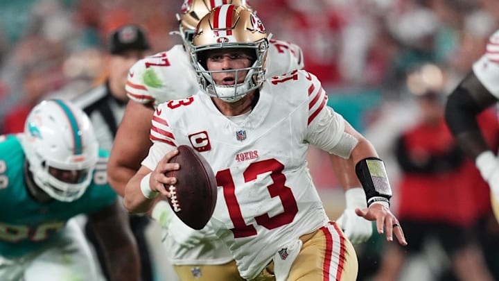 Dec 22, 2024; Miami Gardens, Florida, USA; San Francisco 49ers quarterback Brock Purdy (13) scrambles with the ball against the Miami Dolphins during second half at Hard Rock Stadium. Mandatory Credit: Jasen Vinlove-Imagn Images