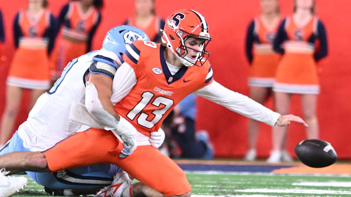 Oct 31, 2025; Syracuse, New York, USA; Syracuse Orange quarterback Joseph Filardi (13) loses a fumble on a tackle by North Carolina Tar Heels defensive lineman Melkart Abou Jaoude (9) in the fourth quarter at the JMA Wireless Dome. Mandatory Credit: Mark Konezny-Imagn Images