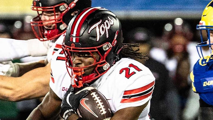 Western Kentucky running back Marvis Parrish (21) runs the ball, with offensive lineman Quincy Jenkins (63) providing cover, against Delaware Blue Hens linebacker Blake Matthews (10) during Delaware's first home CUSA football game, which was nationally televised, at Delaware Stadium in Newark on Oct. 3, 2025. Western Kentucky won 27-24.