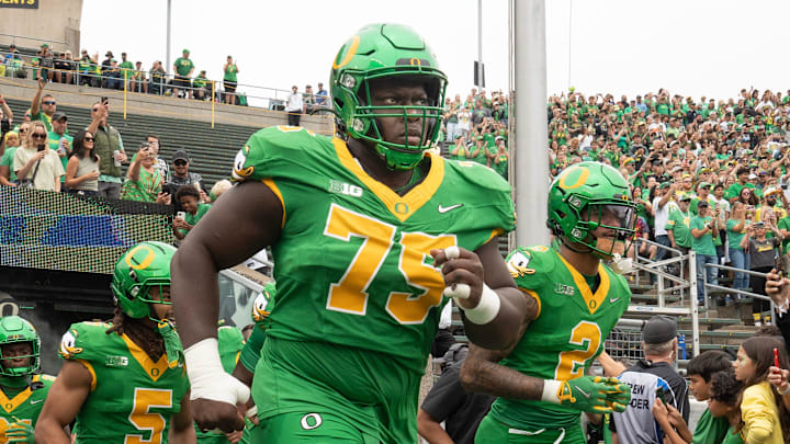 Oregon’s Emmanuel Pregnon, center, takes the field before the game against Oklahoma State at Autzen.
