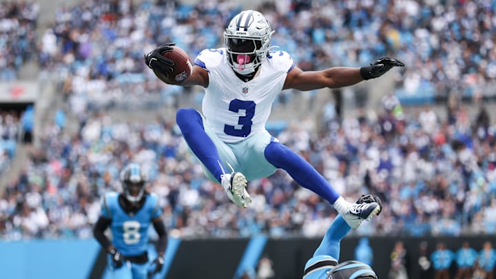 Dallas Cowboys wide receiver George Pickens jumps over Carolina Panthers safety Nick Scott.