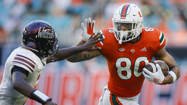 Sep 3, 2022; Miami Gardens, Florida, USA; Miami Hurricanes tight end Elijah Arroyo (80) runs with the football and protects it from Bethune Cookman Wildcats safety Jaquan Jackson (5) during the third quarter at Hard Rock Stadium.