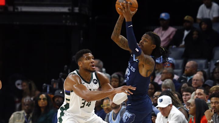 Oct 31, 2024; Memphis, Tennessee, USA; Memphis Grizzlies guard Ja Morant (12) passes the ball as Milwaukee Bucks forward Giannis Antetokounmpo (34) defends during the first half at FedExForum. Mandatory Credit: Petre Thomas-Imagn Images