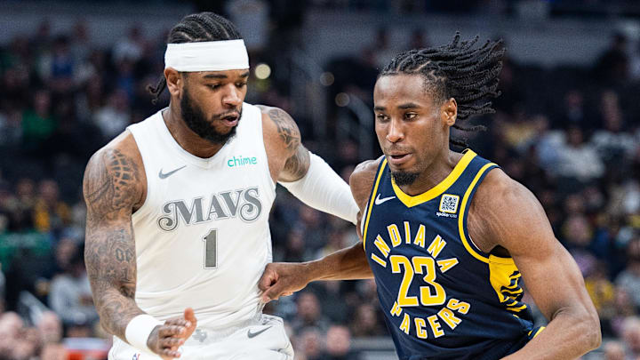 Mar 19, 2025; Indianapolis, Indiana, USA;  Indiana Pacers forward Aaron Nesmith (23) dribbles the ball while Dallas Mavericks guard Jaden Hardy (1) defends in the first half at Gainbridge Fieldhouse. Mandatory Credit: Trevor Ruszkowski-Imagn Images