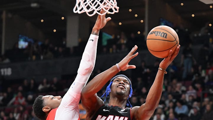 Dec 1, 2024; Toronto, Ontario, CAN;  Miami Heat forward Jimmy Butler (22) shoots the ball as Toronto Raptors forward RJ Barrett (9) defends in the first half at Scotiabank Arena. Mandatory Credit: Dan Hamilton-Imagn Images