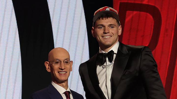 Donovan Clingan poses for photos with NBA commissioner Adam Silver after being selected.