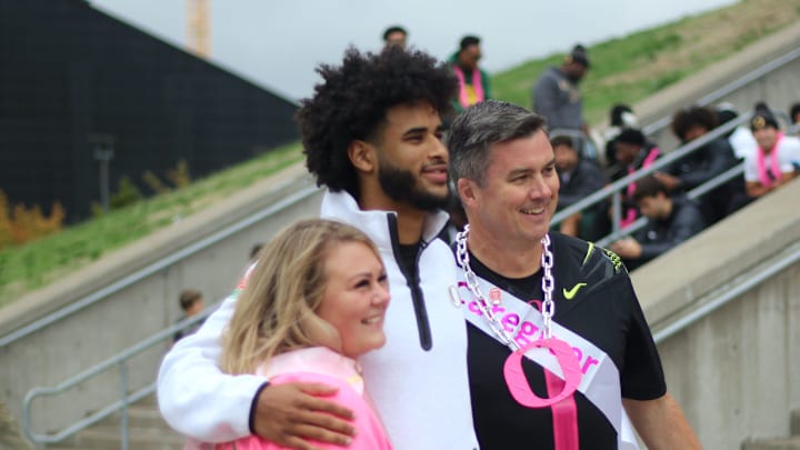 Oregon football quarterback Dante Moore poses with Men Wear Pink of Lane County ambassador James Conners and rally speaker April Brown during a breast cancer awareness rally at Autzen Stadium on Oct. 5, 2025.