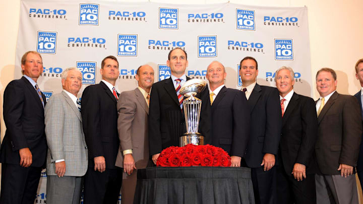 Jul 30, 2009; Los Angeles, CA, USA; Pacific-10 Conference commissioner Larry Scott (center) poses with conference football coaches at media day at the Sheraton Gateway LAX hotel. From left: Steve Sarkisian of Washington, Rick Neuheisel of UCLA, Dennis Erickson of Arizona State, Jim Harbaugh of Stanford, Mike Riley of Oregon State, Scott, Jeff Tedford of California, Paul Wulff of Washington State, Pete Carroll of Southern California, Chip Kelly of Oregon and Mike Stoops of Arizona. Mandatory