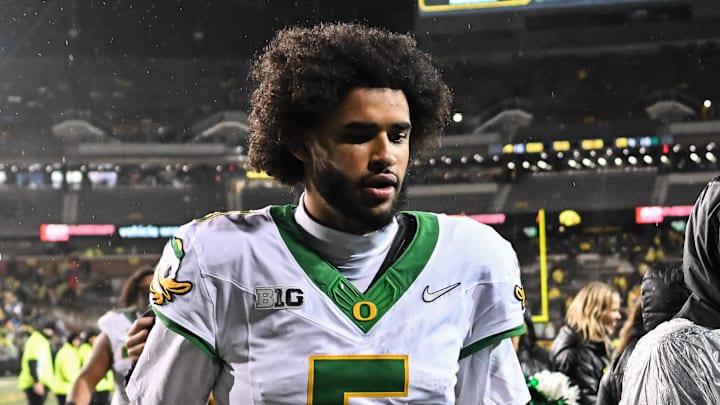 Oregon Ducks quarterback Dante Moore runs off the field after the game against the Iowa Hawkeyes at Kinnick Stadium. Oregon Ducks quarterback Dante Moore runs off the field after the game against the Iowa Hawkeyes at Kinnick Stadium.