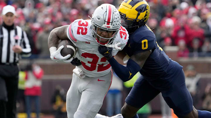 Nov. 25, 2023; Ann Arbor, Mi., USA;
Ohio State Buckeyes running back TreVeyon Henderson (32) is tackled by Michigan Wolverines defensive back Mike Sainristil (0) during the first half of Saturday's NCAA Division I football game at Michigan Stadium.