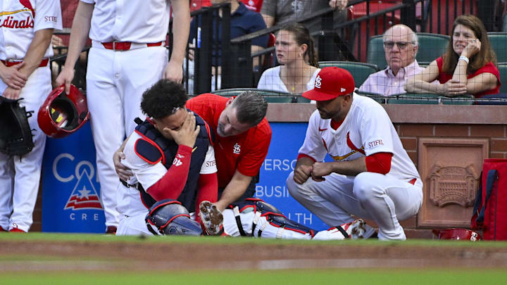 St. Louis Cardinals catcher Willson Contreras is looked at by the team's medical staff. 