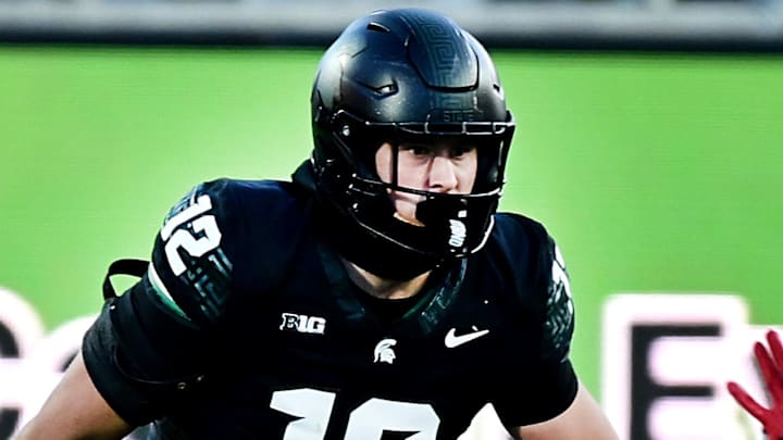 Nov 2, 2024; East Lansing, Michigan, USA;  Michigan State Spartans tight end Jack Velling (12) evades Indiana Hoosiers defensive back Jamier Johnson (9) during the third quarter at Spartan Stadium. Mandatory Credit: Dale Young-Imagn Images
