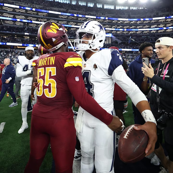 Washington Commanders DE Jacob Martin and Dallas Cowboys quarterback Dak Prescott hug after the game at AT&T Stadium. 