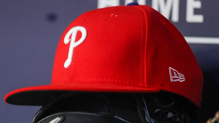 May 26, 2023; Atlanta, Georgia, USA; A detailed view of a Philadelphia Phillies hat and glove on the bench against the Atlanta Braves in the seventh inning at Truist Park. 