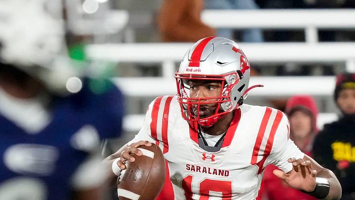Saraland's Jamison Roberts (10) escapes a pass rush to throw a touchdown pass at the end of the first half against Clay-Chalkville at Protective Life Stadium in the AHSAA 6A State Championship game.