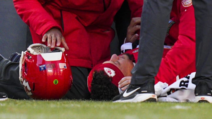 Dec 14, 2025; Kansas City, Missouri, USA; Kansas City Chiefs quarterback Patrick Mahomes (15) is attended to by team medical staff following an injury during the fourth quarter against the Los Angeles Chargers at GEHA Field at Arrowhead Stadium. Kansas City Chiefs head coach Andy Reid, second from right, watches. Mandatory Credit: Jay Biggerstaff-Imagn Images | Jay Biggerstaff-Imagn Images
