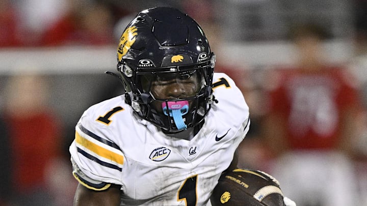 Nov 8, 2025; Louisville, Kentucky, USA;  California Golden Bears running back Kendrick Raphael (1) runs the ball against Louisville Cardinals defensive back Tayon Holloway (25) during the first half at L&N Federal Credit Union Stadium. Mandatory Credit: Jamie Rhodes-Imagn Images