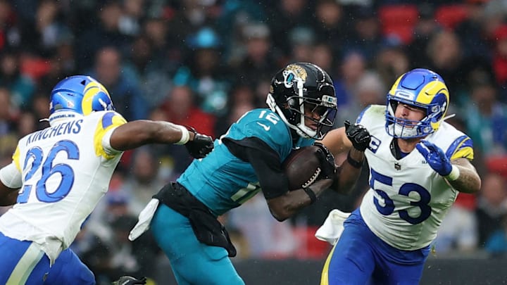 [US, Mexico & Canada customers only] Oct 19, 2025; London, United Kingdom; Jacksonville Jaguars wide receiver Travis Hunter (12) runs with the ball against Los Angeles Rams safety Kamren Kinchens (26) and linebacker Nate Landman (53) during the second half during a NFL International Series game at Wembley Stadium. Mandatory Credit: Andrew Boyers-Reuters via Imagn Images