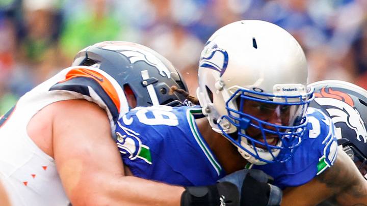Seattle Seahawks defensive end Leonard Williams tackles running back Javonte Williams. Seattle Seahawks defensive end Leonard Williams tackles running back Javonte Williams.
