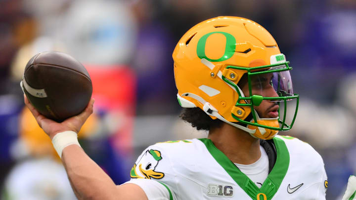 Nov 29, 2025; Seattle, Washington, USA; Oregon Ducks quarterback Dante Moore (5) passes the ball against the Washington Huskies during the first half at Husky Stadium. Mandatory Credit: Steven Bisig-Imagn Images
