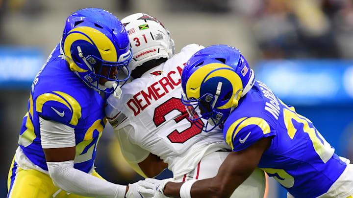 Jan 4, 2026; Inglewood, California, USA;  Arizona Cardinals running back Emari Demercado (31) is tackled Los Angeles Rams running back Ronnie Rivers (20) and. cornerback Roger McCreary (25)  during the first half at SoFi Stadium. Mandatory Credit: Gary A. Vasquez-Imagn Images