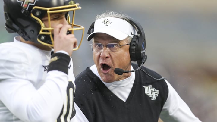 Nov 23, 2024; Morgantown, West Virginia, USA; UCF Knights head coach Gus Malzahn yells at quarterback Dylan Rizk (10) during the first quarter against the West Virginia Mountaineers at Mountaineer Field at Milan Puskar Stadium. Mandatory Credit: Ben Queen-Imagn Images Nov 23, 2024; Morgantown, West Virginia, USA; UCF Knights head coach Gus Malzahn yells at quarterback Dylan Rizk (10) during the first quarter against the West Virginia Mountaineers at Mountaineer Field at Milan Puskar Stadium. Mandatory Credit: Ben Queen-Imagn Images